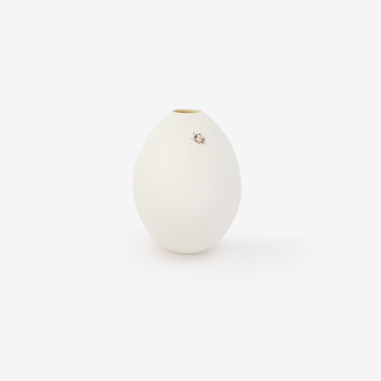 TED MUEHLING SMALL WHITE BISQUE GOOSE EGG VASE WITH PAINTED SMALL LADYBUG